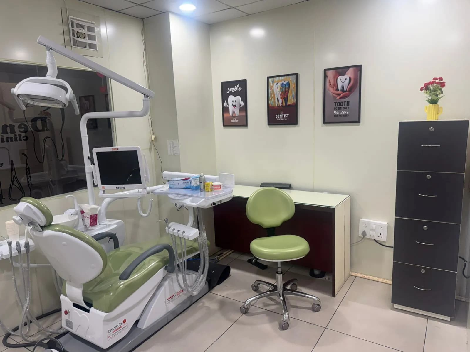 Wider view of the treatment room showing the chair, instrument tray, work counter and storage.